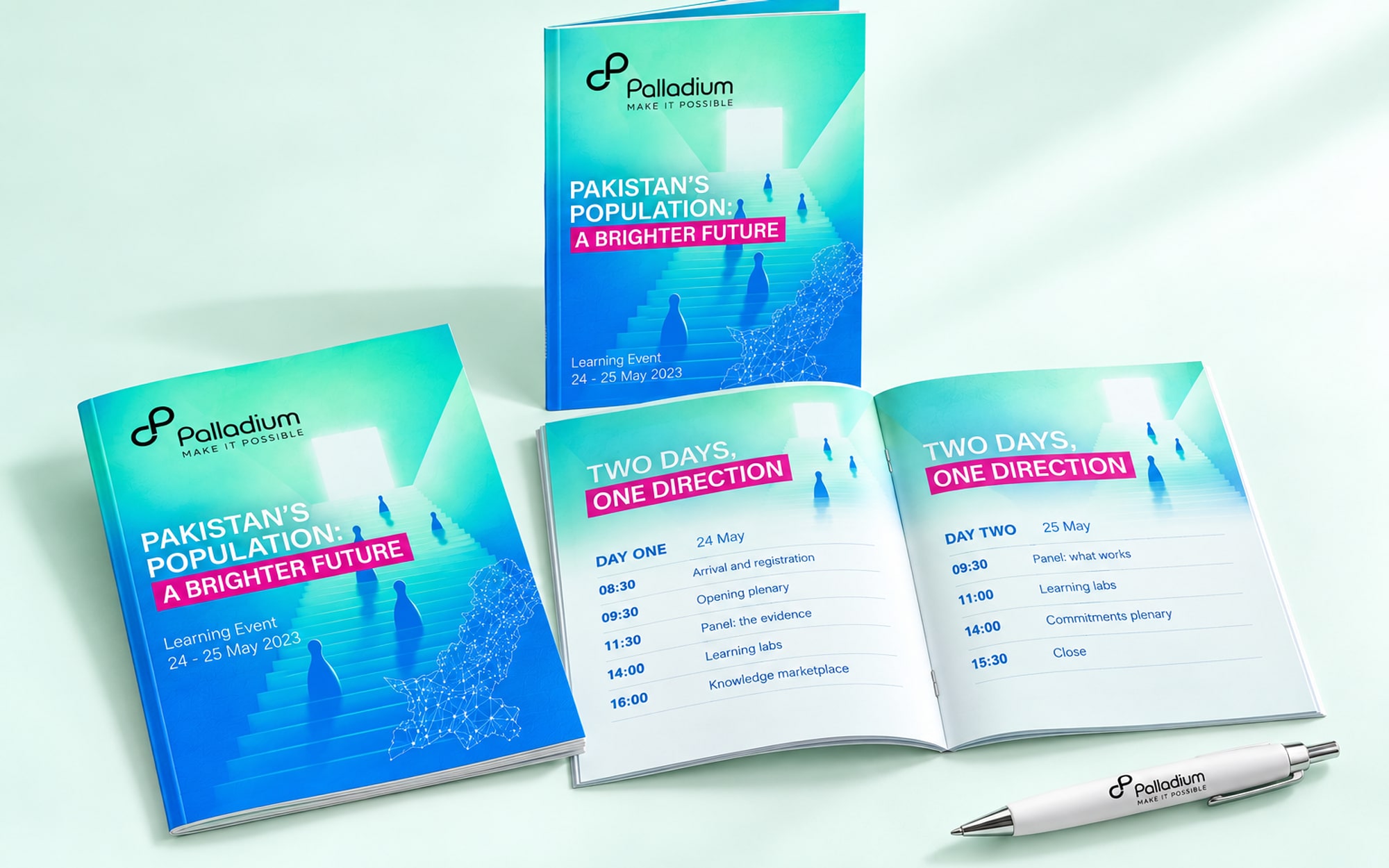 Three copies of a slim programme booklet, one closed, one standing and one open at the agenda