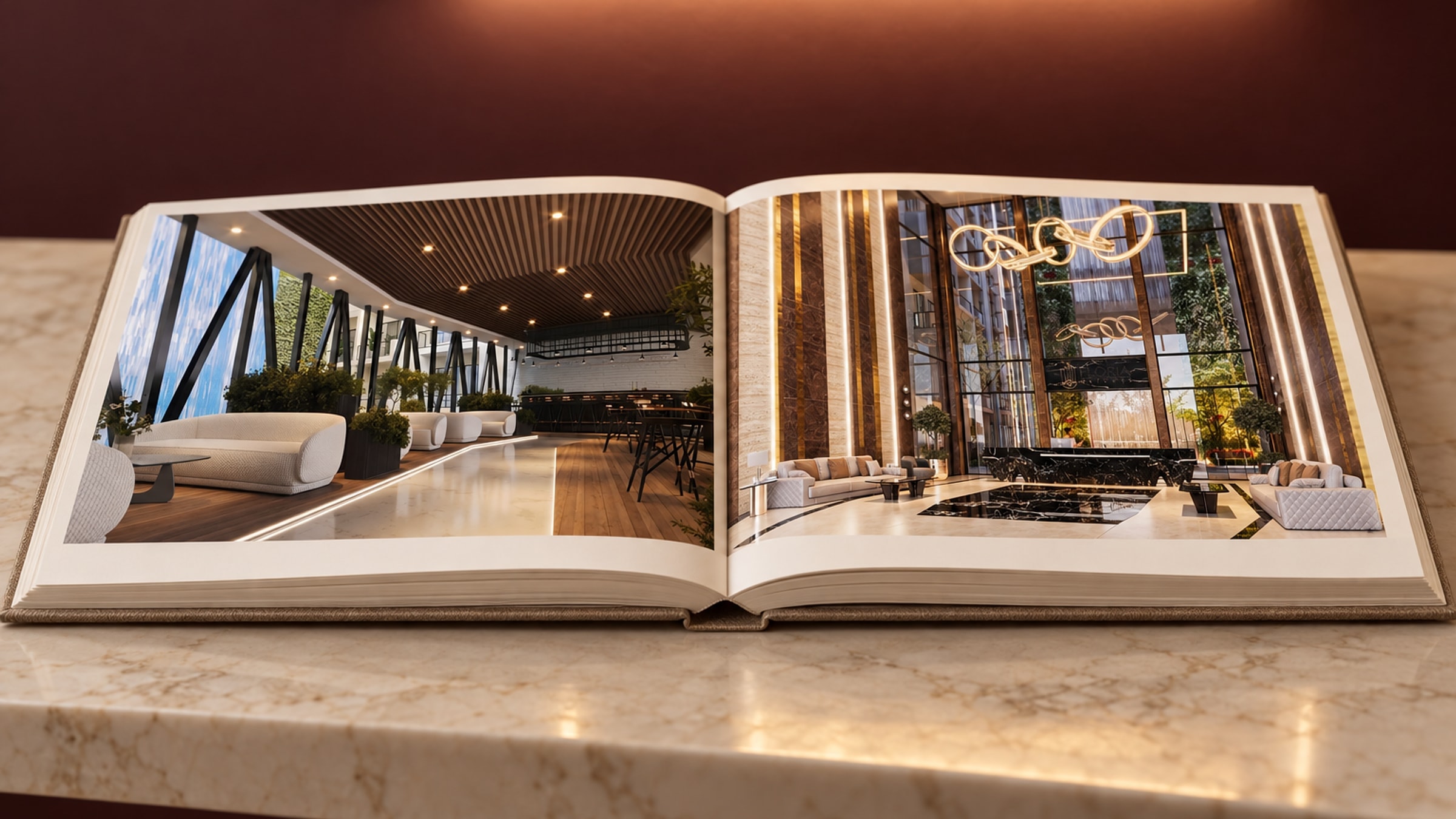 The book open on a marble console: the café render on the left page, the lobby with its ring chandelier on the right