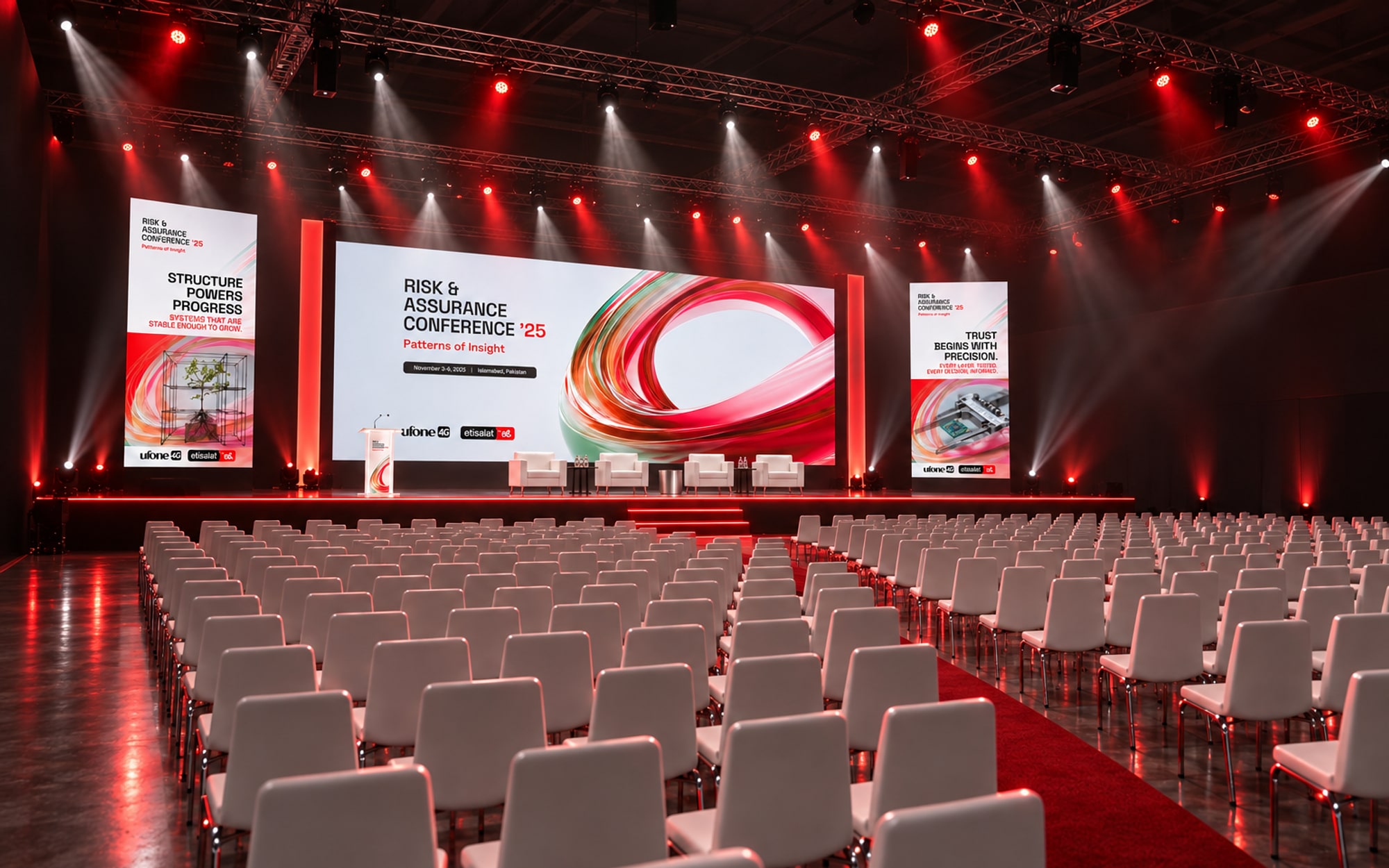 The plenary hall seen diagonally from the back corner: rows of white chairs running towards the stage, the key visual on the main screen and a portrait screen either side
