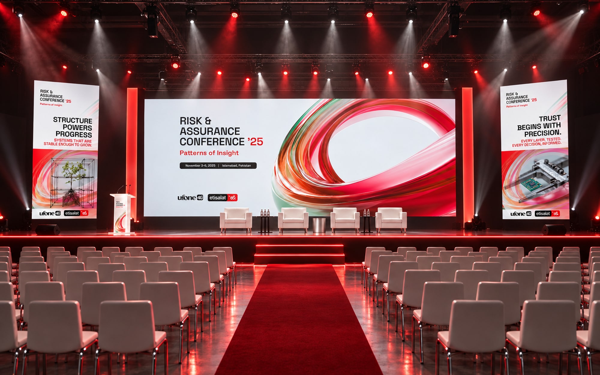 The plenary stage from the centre aisle: the key visual on the main screen, two portrait panel screens at the sides, a lectern and four white armchairs, red aisle carpet between rows of white chairs, red and white beams overhead